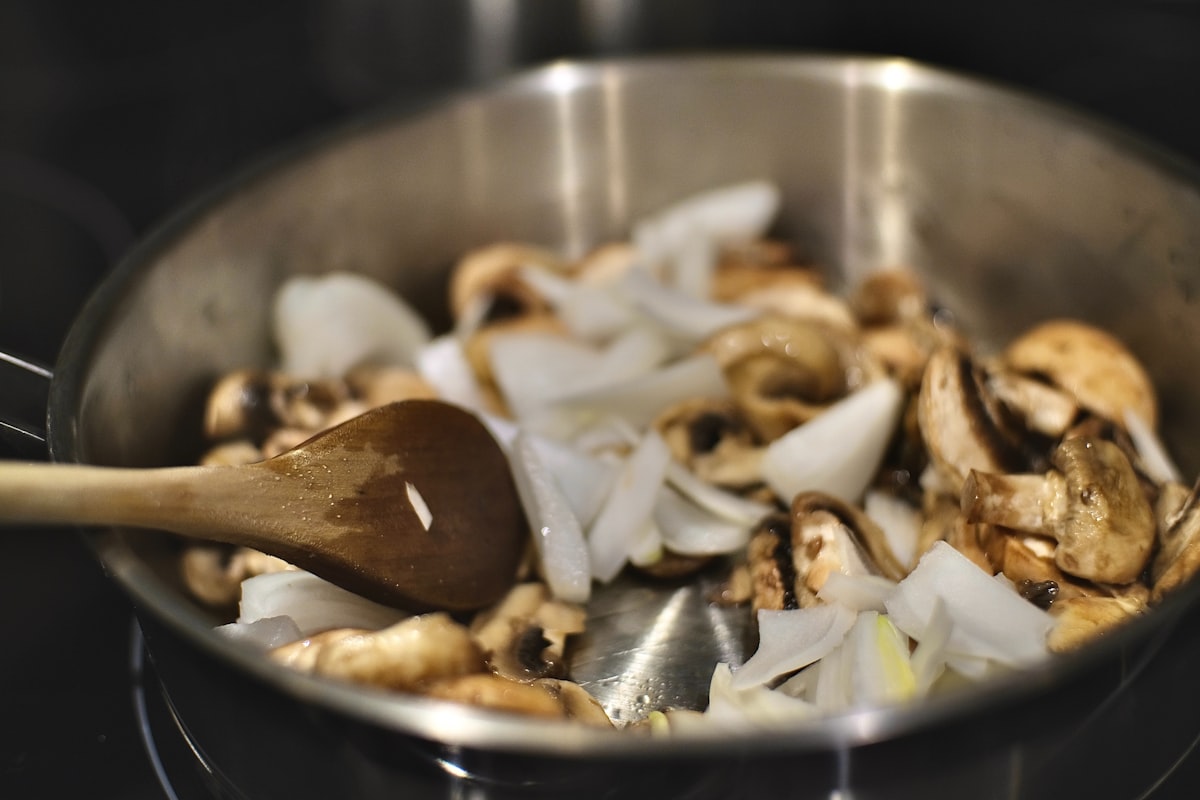 Three fresh porcini mushrooms on a wooden surface, ready for cooking