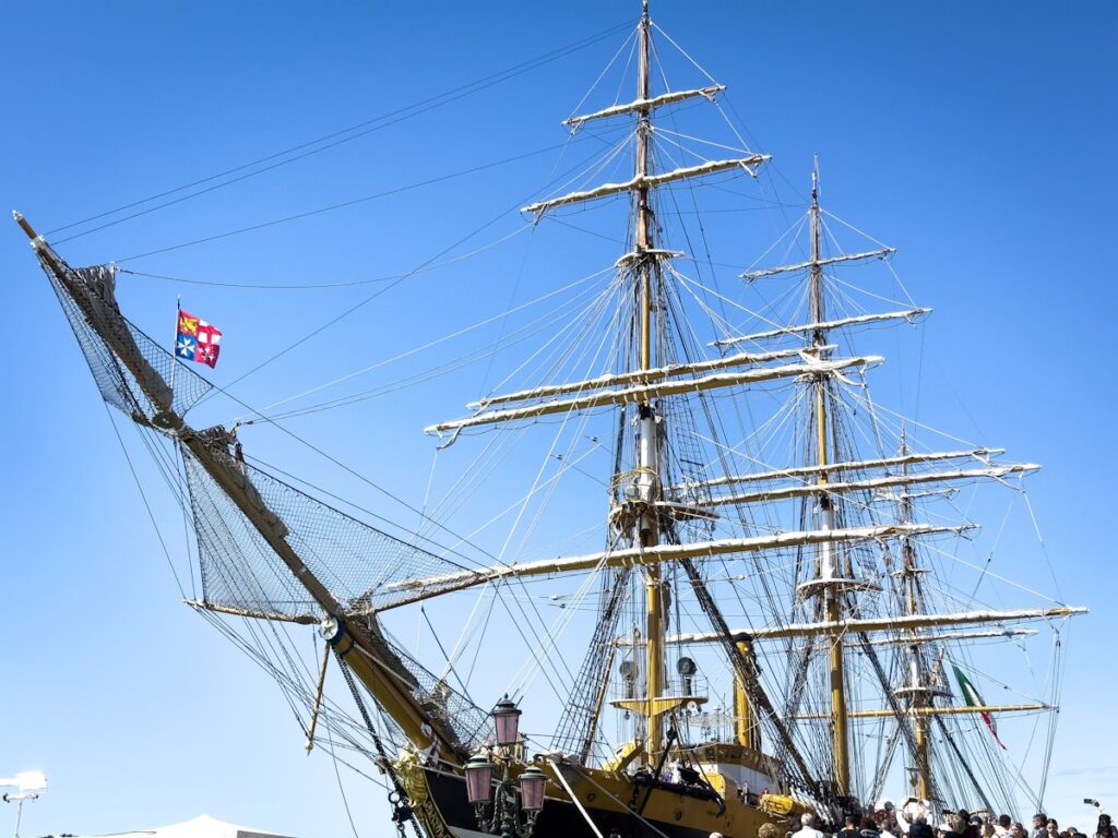 The Amerigo Vespucci with sailors lined up on the yards during a salute maneuver on the open sea