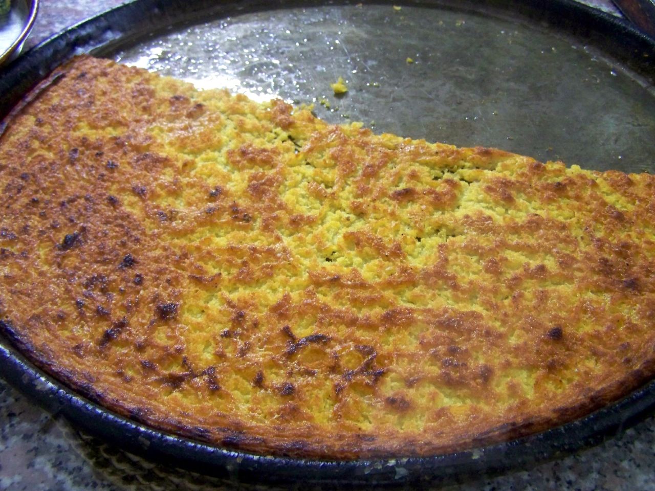 Golden chickpea farinata fresh from the oven in the traditional copper pan