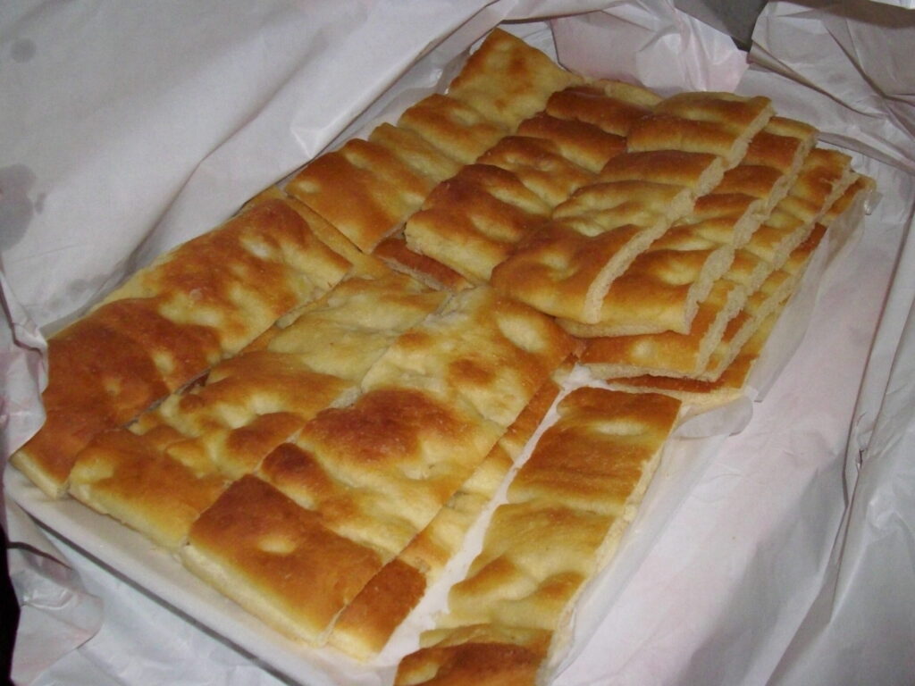 Focaccia genovese tagliata a strisce, tipica presentazione del forno al mattino