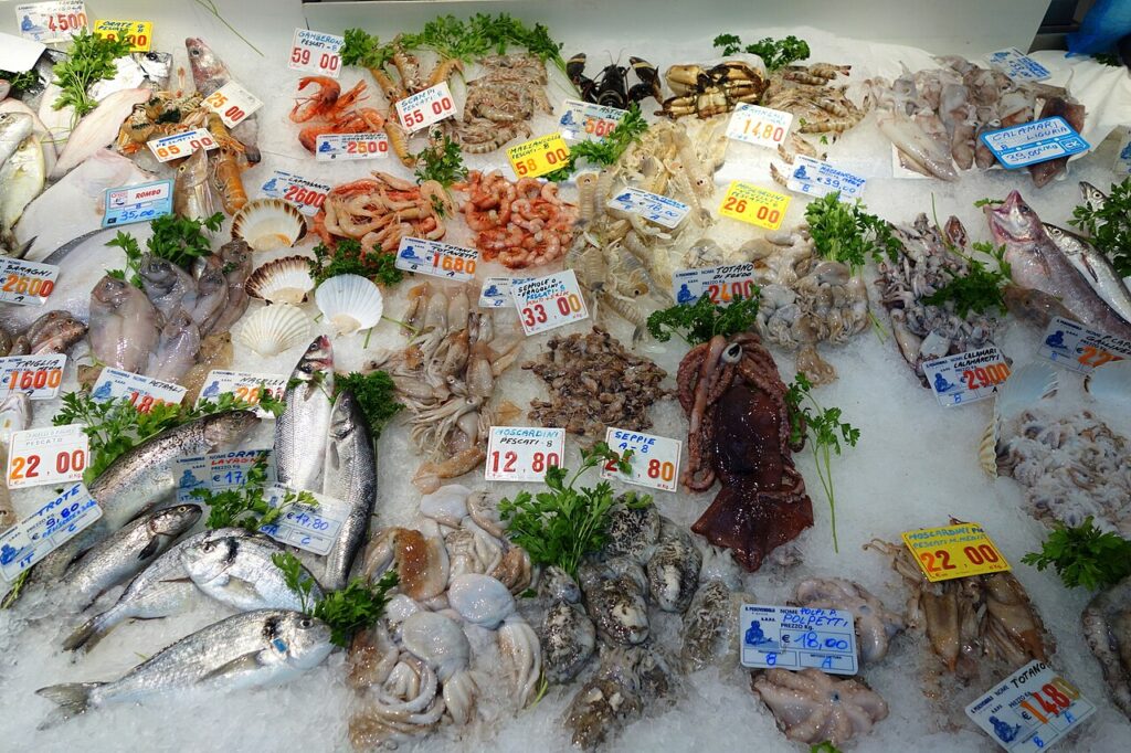 Fresh fish counter at Mercato Orientale in Genoa with sea bass, red mullet and seafood on ice