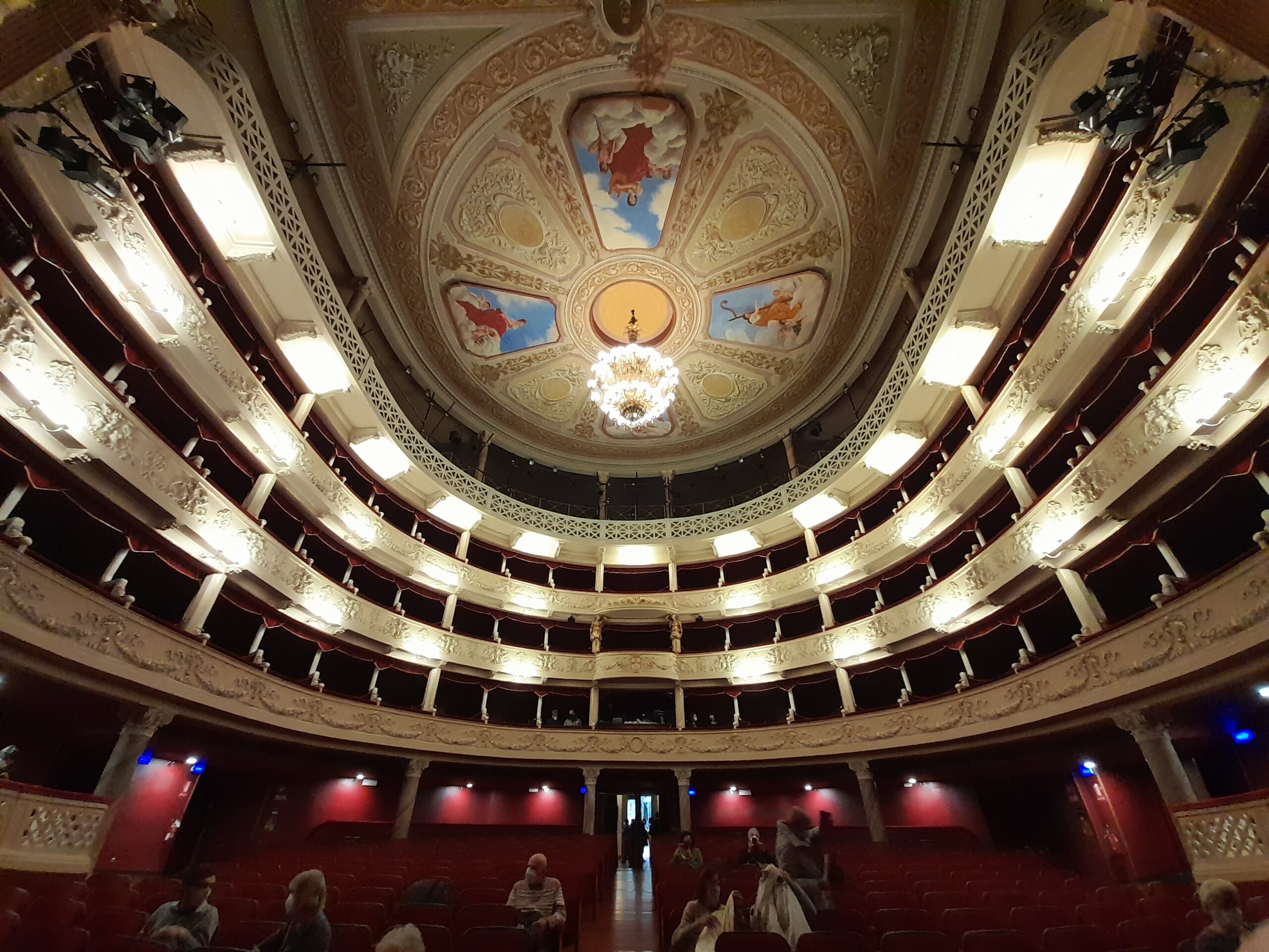 Interno del Teatro Gustavo Modena con affreschi del soffitto, lampadario e palchi illuminati