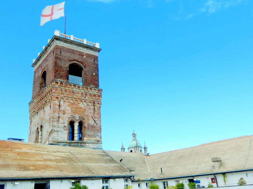The Grimaldina Tower with the Genoa flag and San Lorenzo dome
