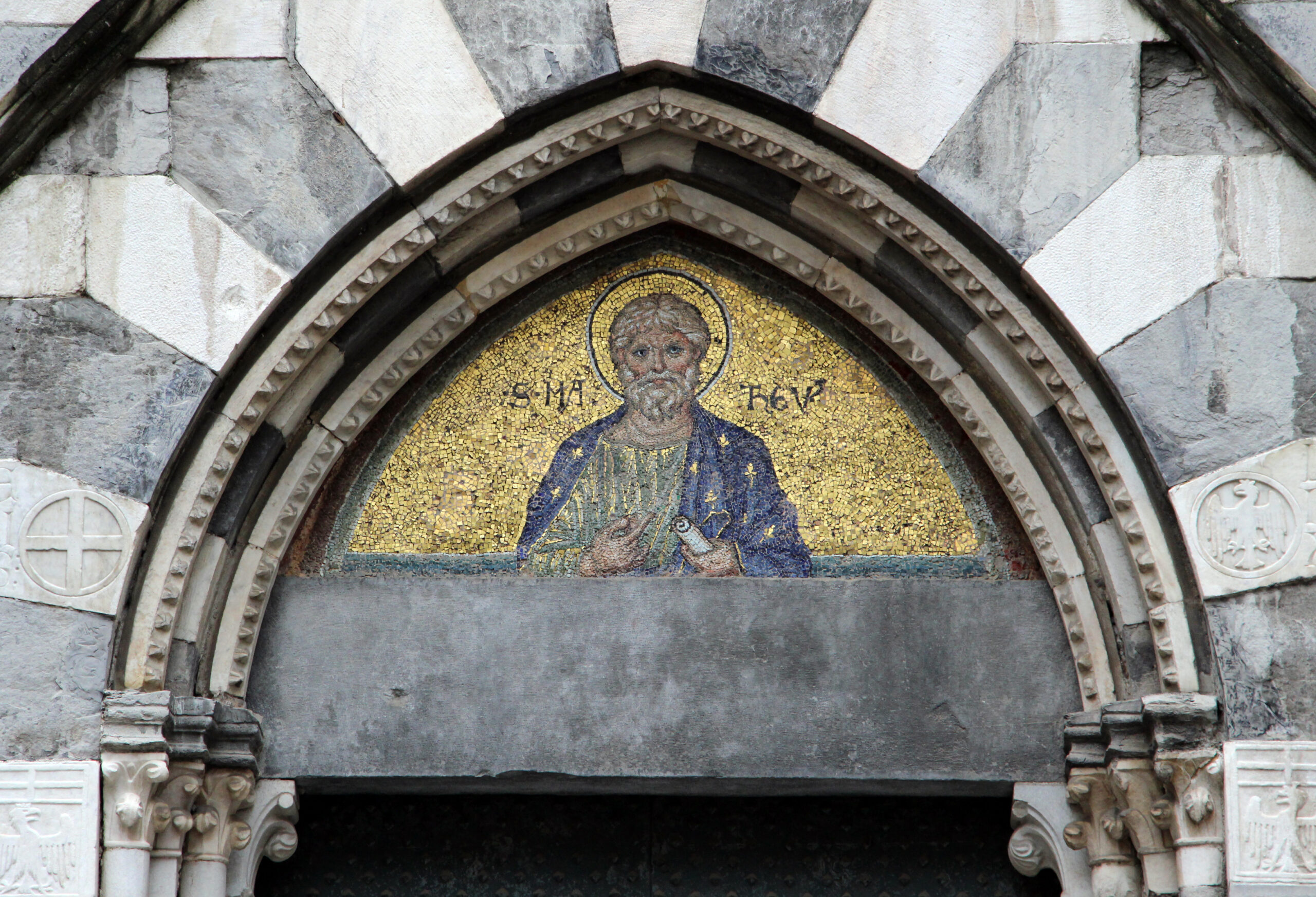 Medieval gilded mosaic of Saint Matthew above the Gothic portal of the Doria family church