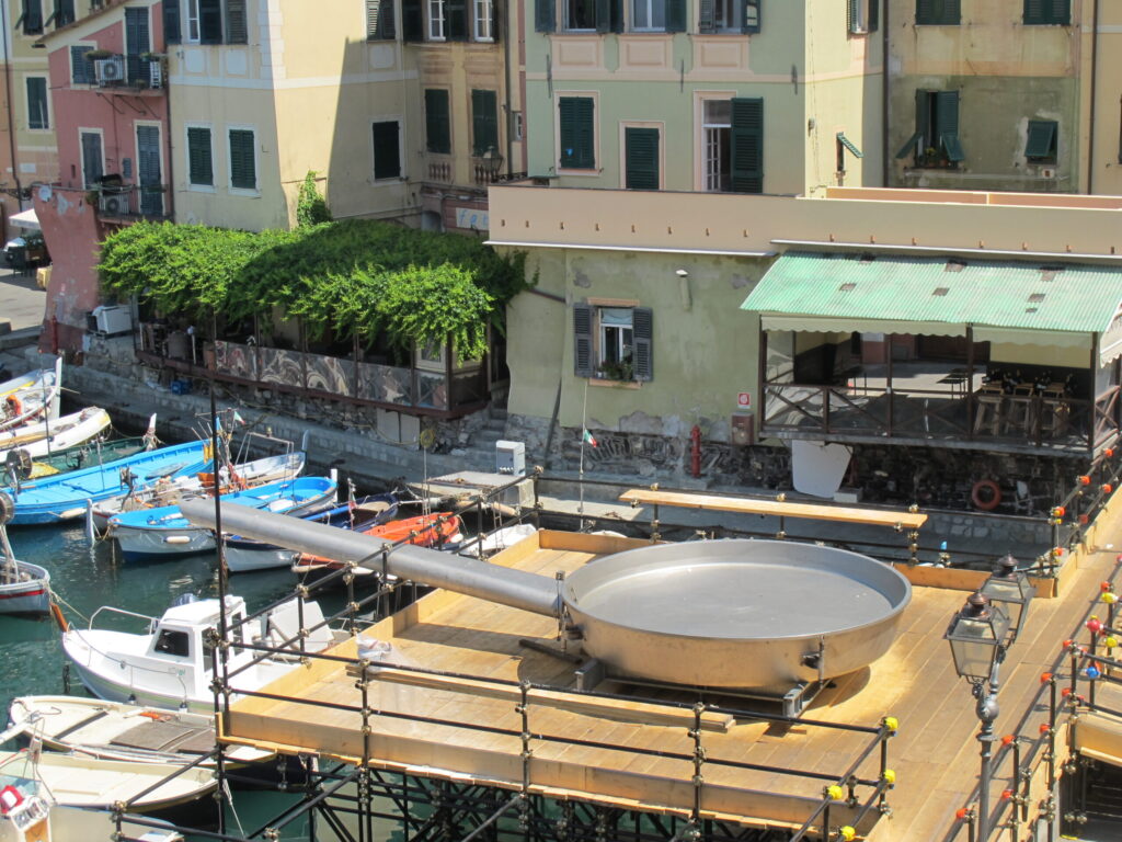 The giant frying pan of Camogli overlooking the harbour, with boats and colourful houses in the background