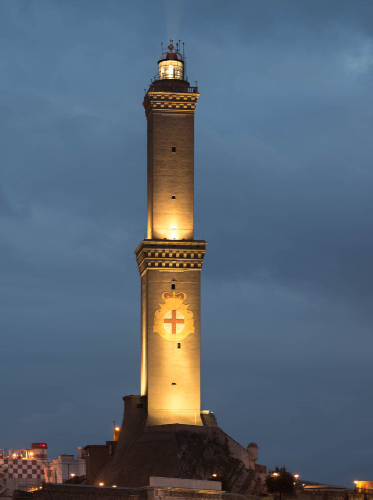La Lanterna di Genova illuminata al tramonto: il faro medievale con lo stemma cittadino sulla facciata