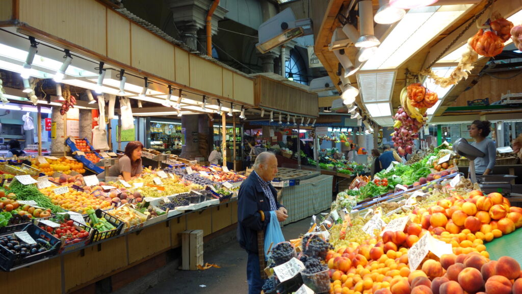 Interno del Mercato Orientale di Genova con banchi di frutta e verdura