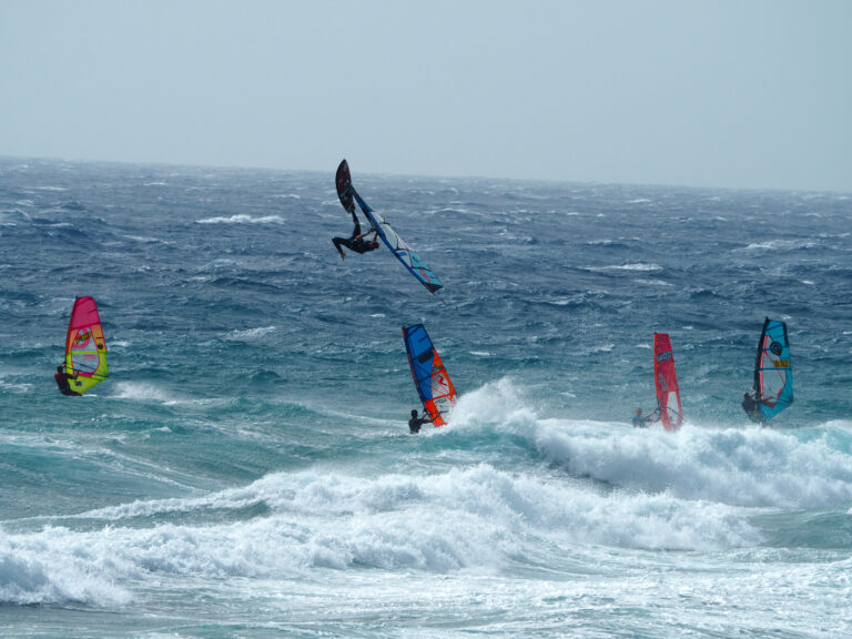Windsurfista in salto sopra le onde, sport del vento sul mare