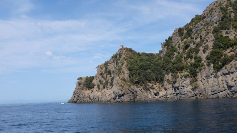 Il promontorio del Monte di Portofino a picco sul mare, con le falesie di puddinga e la torre sul crinale