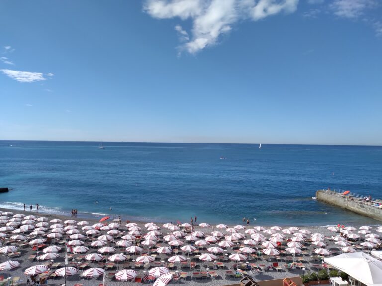 Spiaggia genovese con ombrelloni e mare blu nel giorno di Ferragosto