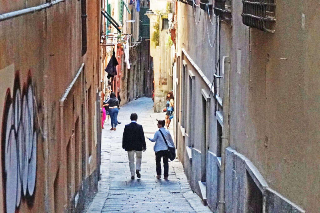 An alleyway in Genoa's historic center with passers-by