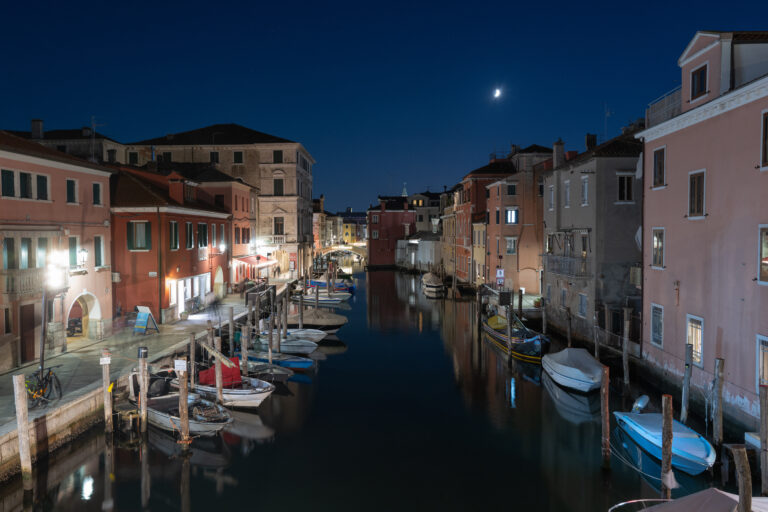 Il Canal Vena di Chioggia all'ora blu, con le barche ormeggiate e le case illuminate